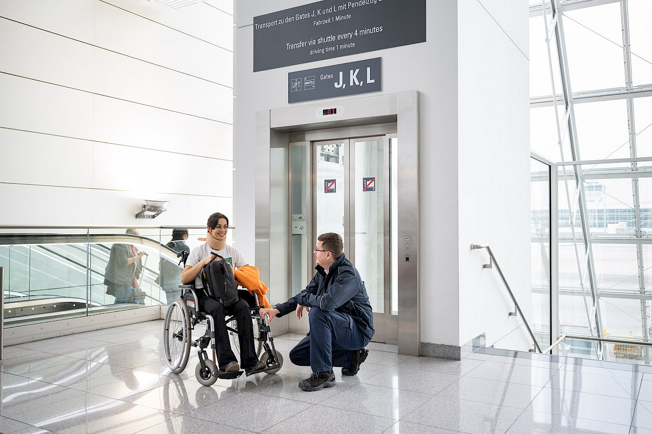 Service Mitarbeiter des Aicher Mobility Service spricht mit junger Frau im Rollstuhl