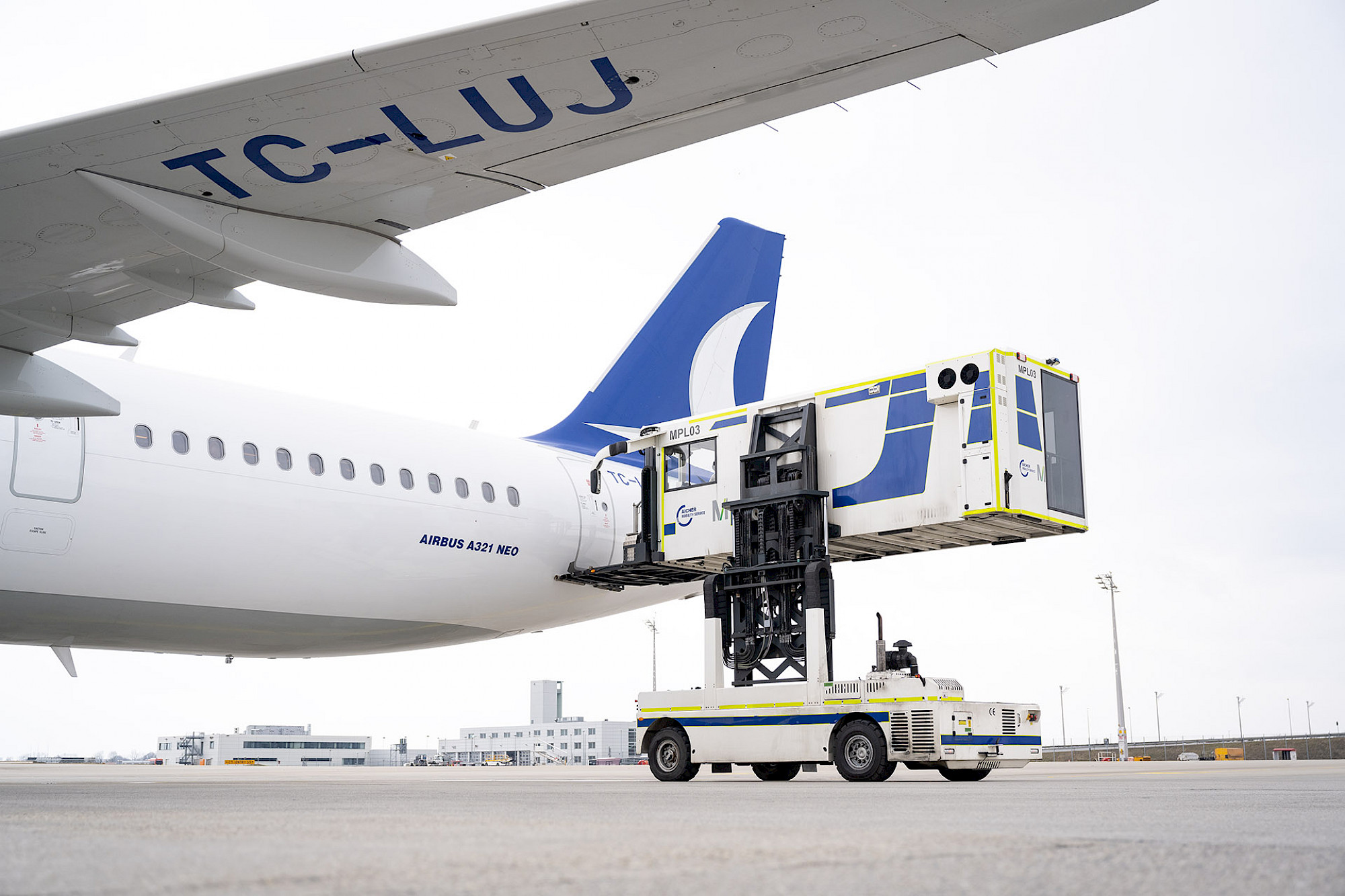 Ein Hublifter für das sichere Anheben von Rollstühlen dockt an den Eingang eines Airbus an.
