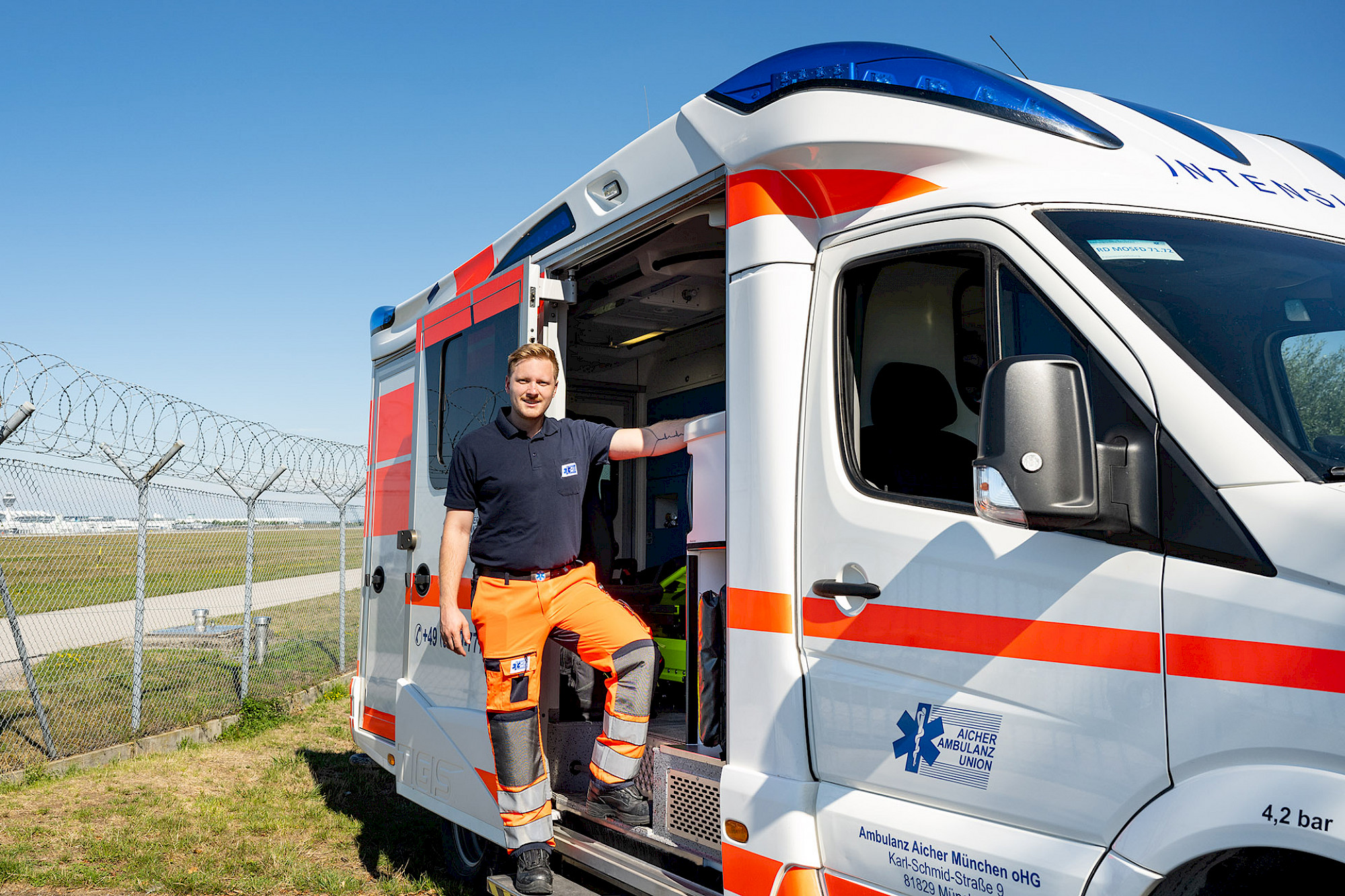 Ein Rettungssanitäter steht in der Seitentür eines Rettungswagens.